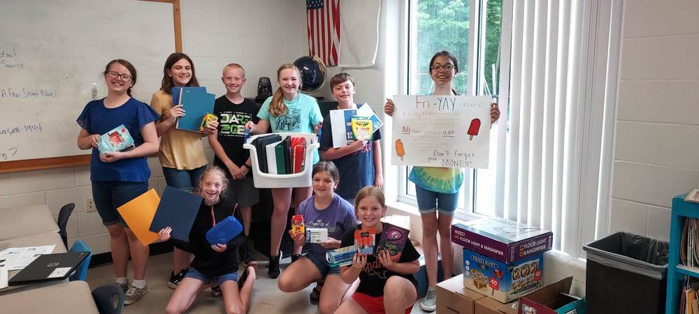 students holding school supplies