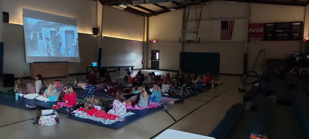 kids watching a movie in gym